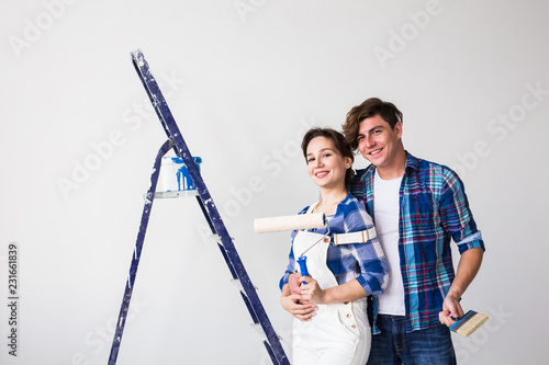 People, redecoration and repair concept - Lovely young couple doing renovation in new apartment