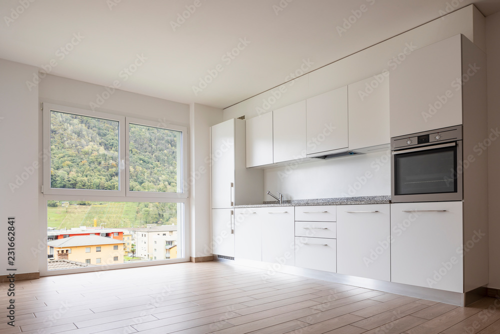 Living room with kitchen and large white wall Living room with kitchen and large white wall