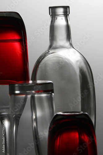 A transparent bottle and red glasses