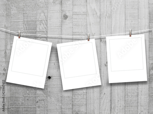 Three square blank instant photo frames on grey concrete wall background