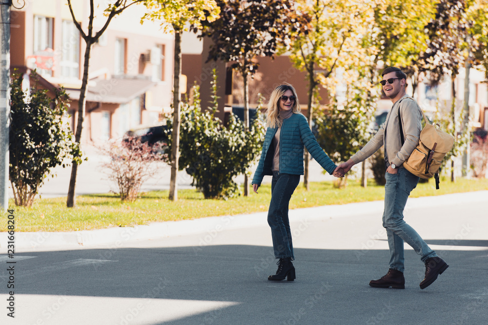 couple holding hands while walking together in new city couple holding hands while walking together in new city