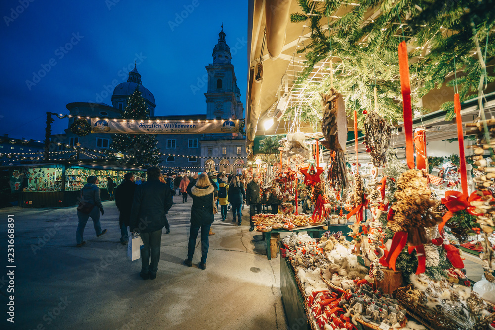 Fototapeta premium Salzburg Christmas Christkindl Adwent Jarmark widziany przez gałęzie choinki