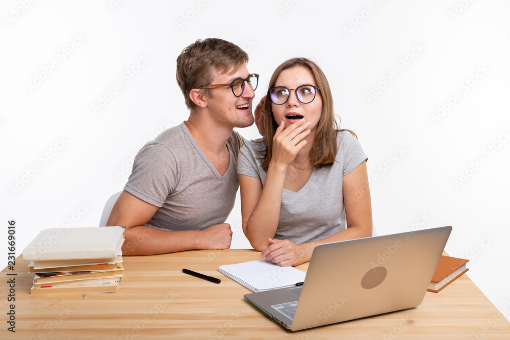 Education and people concept - couple of students look like they are surprised of something in their laptop Education and people concept - couple of students look like they are surprised of something in their laptop