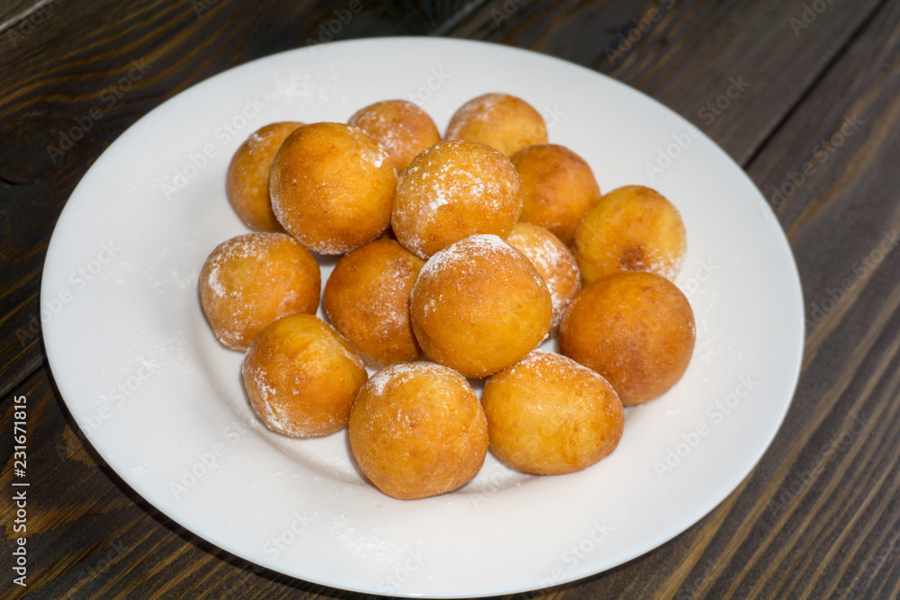 ball shape donuts, on white plate, wooden background ball shape donuts, on white plate, wooden background