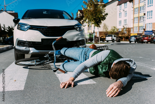 male bicycle rider hit by car on road, car accident concept