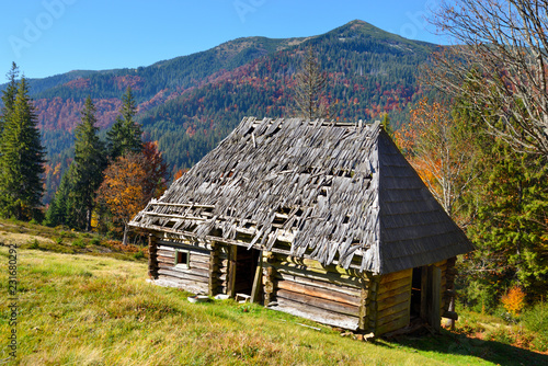 Beautiful landscape with old wooden hut in the Carpathians mountains. Autumn sunny day.