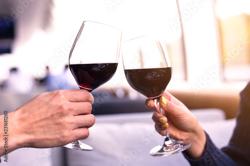 Selective focus of Mid adult Caucasian male and female hands toasting wine glasses in the room on the Boat cruises.