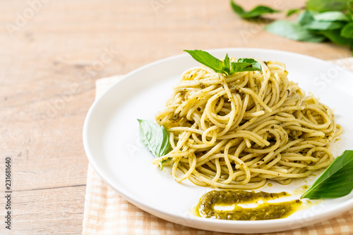 spaghetti with pesto sauce  olive oil and basil leaves.
