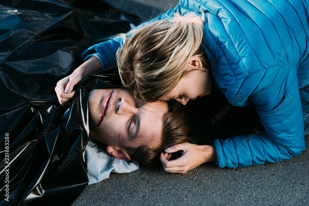 young woman crying and hugging dead man on road Stock Photo | Adobe Stock
