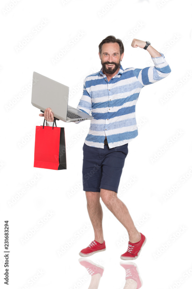 Happy bearded man showing his muscles while standing with laptop Happy bearded man showing his muscles while standing with laptop