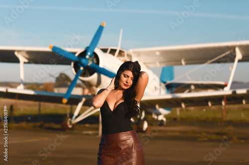 Beautiful sexy girl in leather skirts, Surround bust near the ancient airplane. Fashion Lifestyle, Portrait