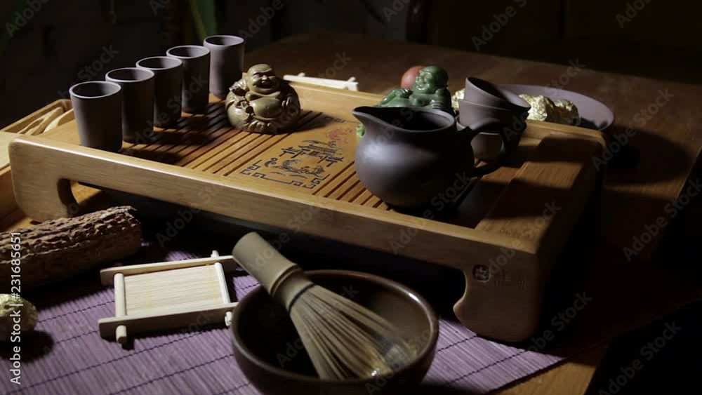 Wooden tea board with traditional Chinese cups and tipot for Chinese tea ceremony on the warm dark background. Wooden tea board with traditional Chinese cups and tipot for Chinese tea ceremony on the warm dark background.