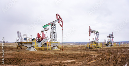The oil pump, industrial equipment. Oil field site, oil pumps are running. Rocking machines for oil production