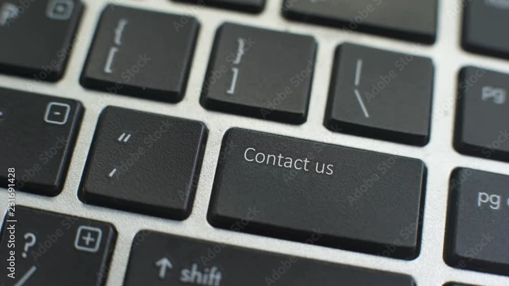Contact us button on computer keyboard, female hand fingers press key Contact us button on computer keyboard, female hand fingers press key