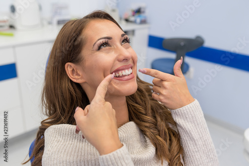 Woman smiling and pointing at mouth