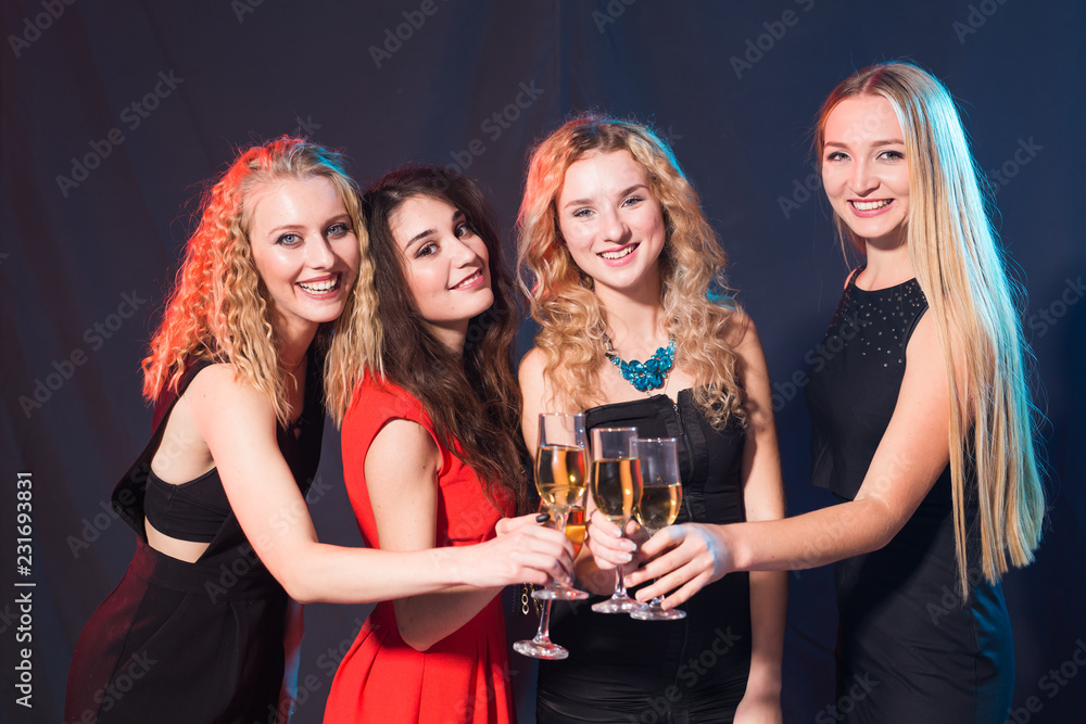 Party, holidays, celebration and new year eve concept - Cheerful young woman clinking glasses of champagne at the party