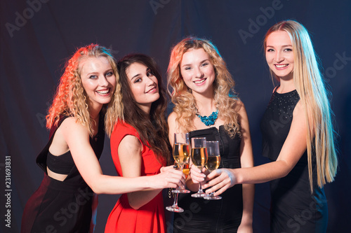 Party, holidays, celebration and new year eve concept - Cheerful young woman clinking glasses of champagne at the party