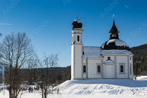 landmark Seekirchl church in Seefeld covered in snow on sunny winter day photo