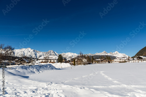 Seefeld village view over snowy field on sunny winter day