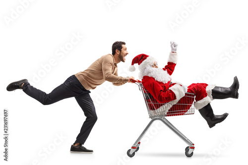 Young man pushing Santa Claus inside a shopping cart photo