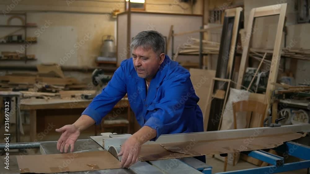 Carpenter at work at his workshop, wood processing on a woodworking machine Carpenter at work at his workshop, wood processing on a woodworking machine
