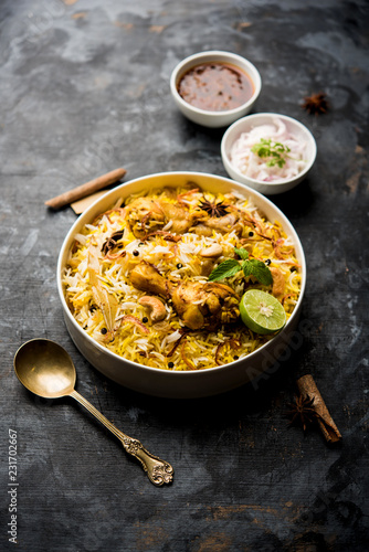 Delicious spicy chicken biryani in bowl over moody background, it’s a popular Indian and Pakistani food.
