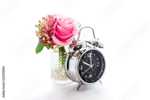 Artificial plastic flowers and clock isolated on white background. photo