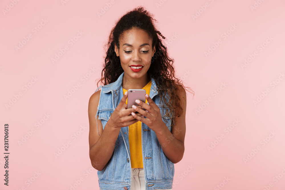 Young happy beautiful woman posing isolated over pink background chatting by phone. Young happy beautiful woman posing isolated over pink background chatting by phone.