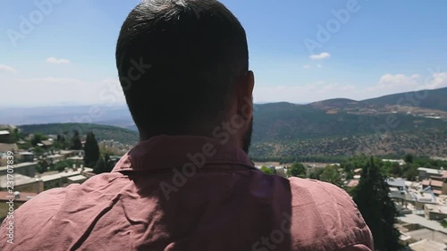 Young man looking at mountain, enjoying landscape nature background. Safed, Upper Galilee, Israel. Slow motion. Vacation concept. photo