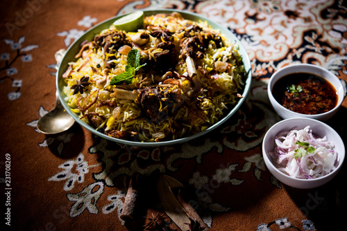 mutton or lamb biriyani with basmati rice, served in a bowl over moody background. photo