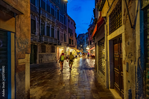 Tourist couple on the night streets of Venice