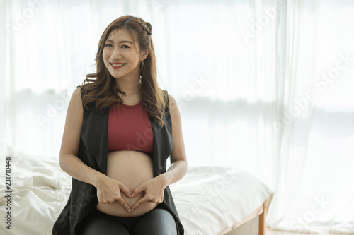 Free Download Attractive Pregnant woman holding on belly making shaping a heart for love and happiness,Healthy Pregnant Concept - GFXLoad