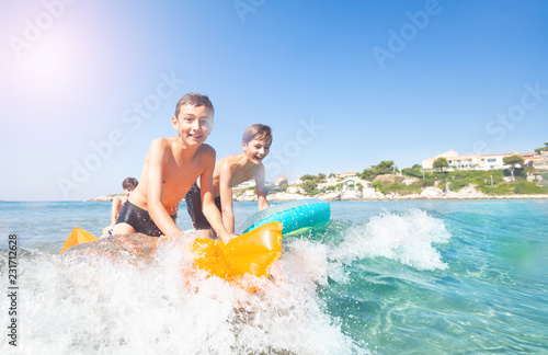 Active boys learning to ride the waves at seaside © Sergey Novikov