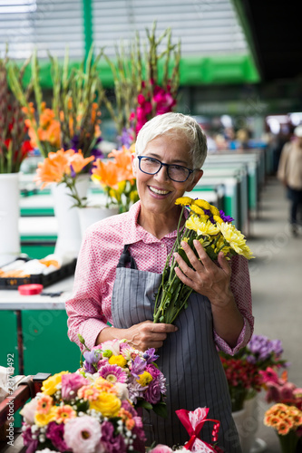 Senior woman sales flowers on local flower market