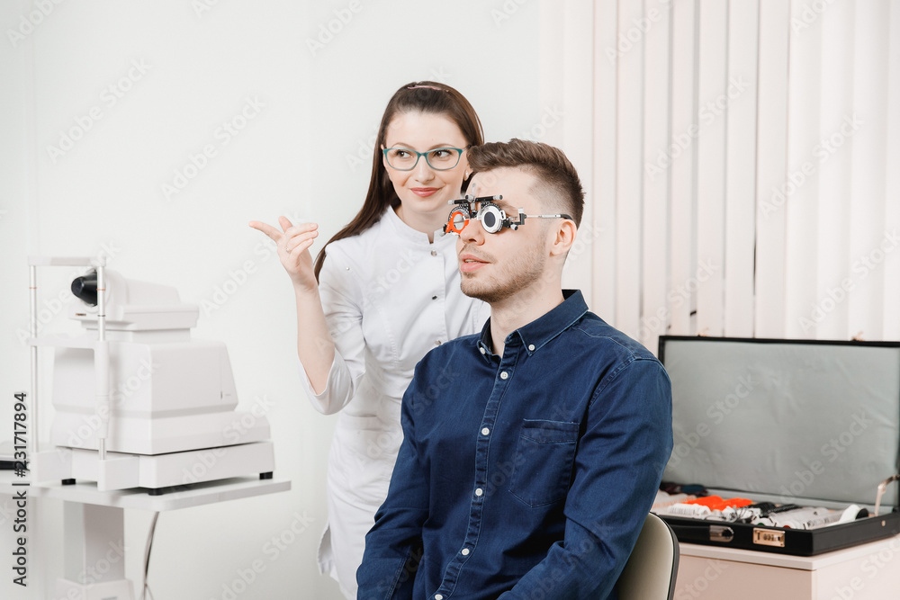 Attractive dark-haired girl doctor ophthalmologist smiles Attractive dark-haired girl doctor ophthalmologist smiles