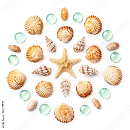 Pattern in the form of a circle made of shells, starfish and green glass beads isolated on white background