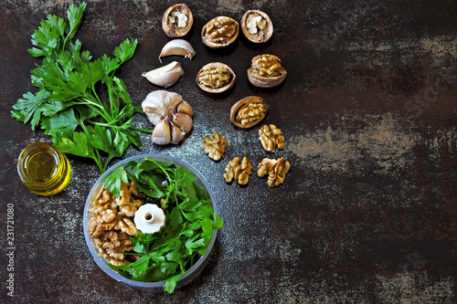 Cooking pesto sauce with walnuts and parsley. Walnut Pesto. Ingredients for walnut pesto in a blender cup. Vegan pesto.