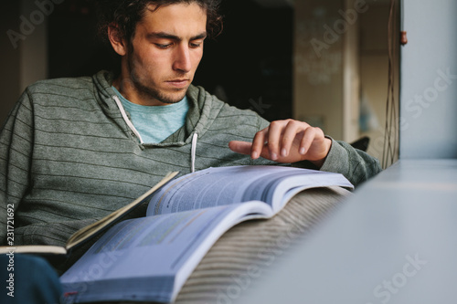 Student using reference book to make notes photo