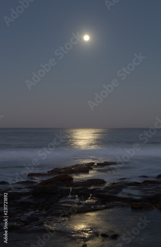 Night seascape with moon and light reflecting on the water