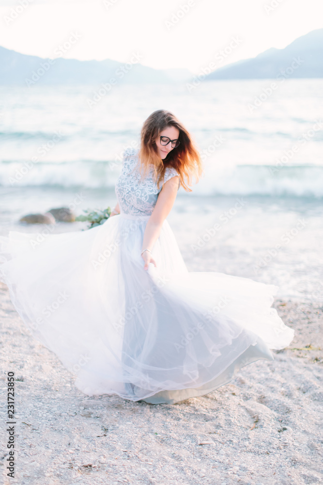 Romantic family concept. Young pretty woman in luxury blue wedding dress walking near the Garda Lake, Sirmione, Italy Romantic family concept. Young pretty woman in luxury blue wedding dress walking near the Garda Lake, Sirmione, Italy