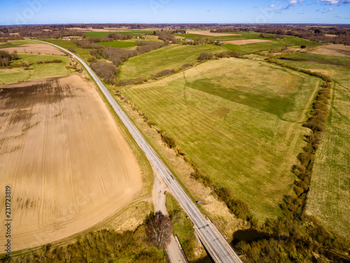 drone image. aerial view of rural area with fields and forests with river and water reflections