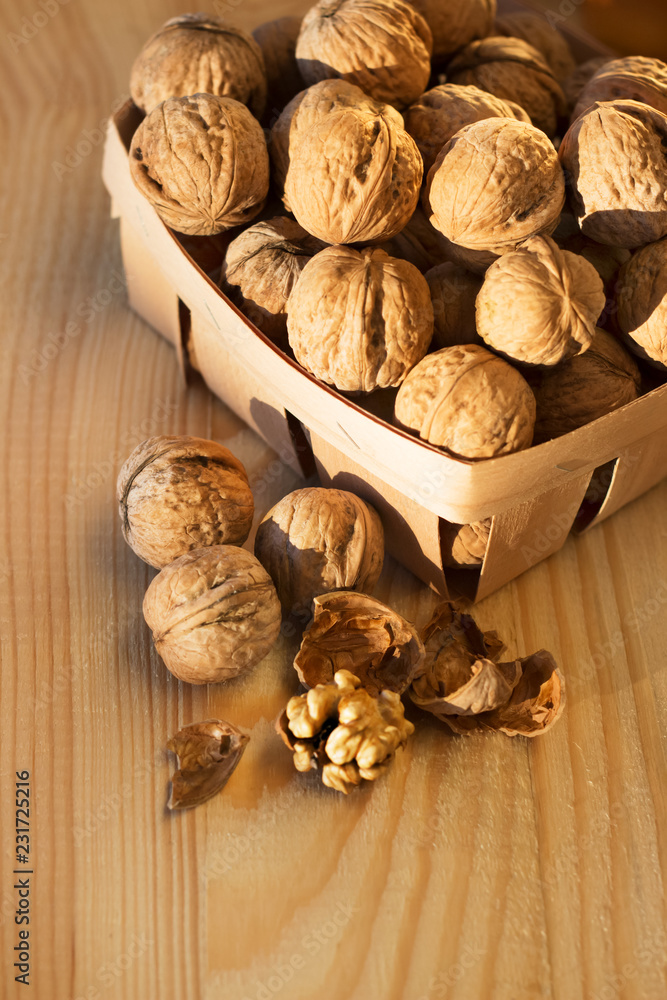 .walnuts peeled and whole on a wooden table in a natural ecological packaging basket
