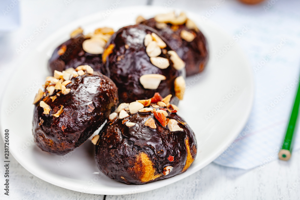 Cookie balls with chocolate glaze and walnuts on white plate. Close up Cookie balls with chocolate glaze and walnuts on white plate. Close up