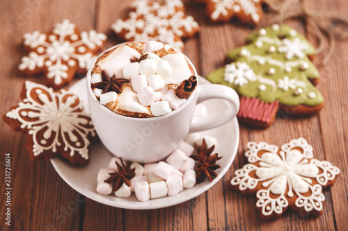 Christmas or new year background. A Cup of festive hot chocolate or cocoa with marshmallows and traditional handmade gingerbread on the table. The concept of advertising cocoa drink. 