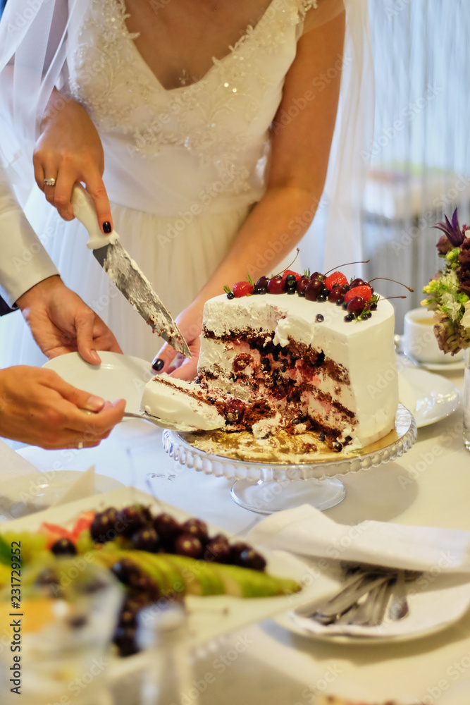 Beauty bride and handsome groom are cutting a wedding cake. wedding