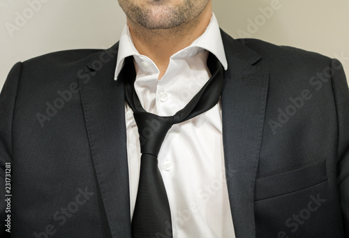 Business man wearing suit loosen his tie after tiring day.