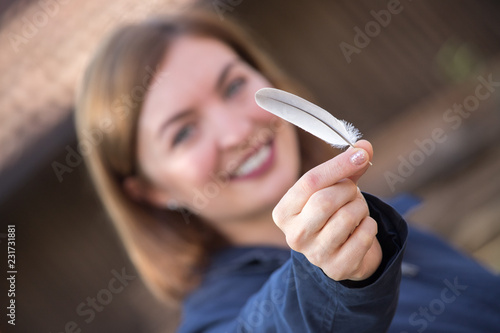 Young smiling girl with feather photo