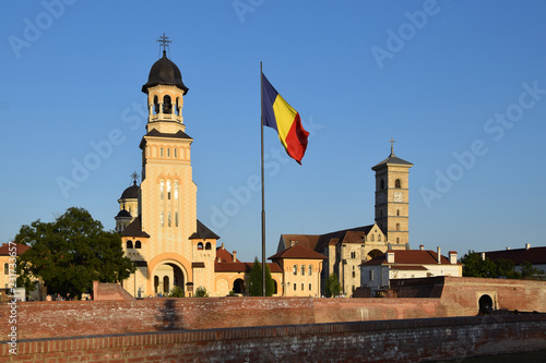 Orthodox Reunification Cathedral and Catholic St. Michael's Cathedral, with Romania flag. Alba Iulia in Transylvania, Romania