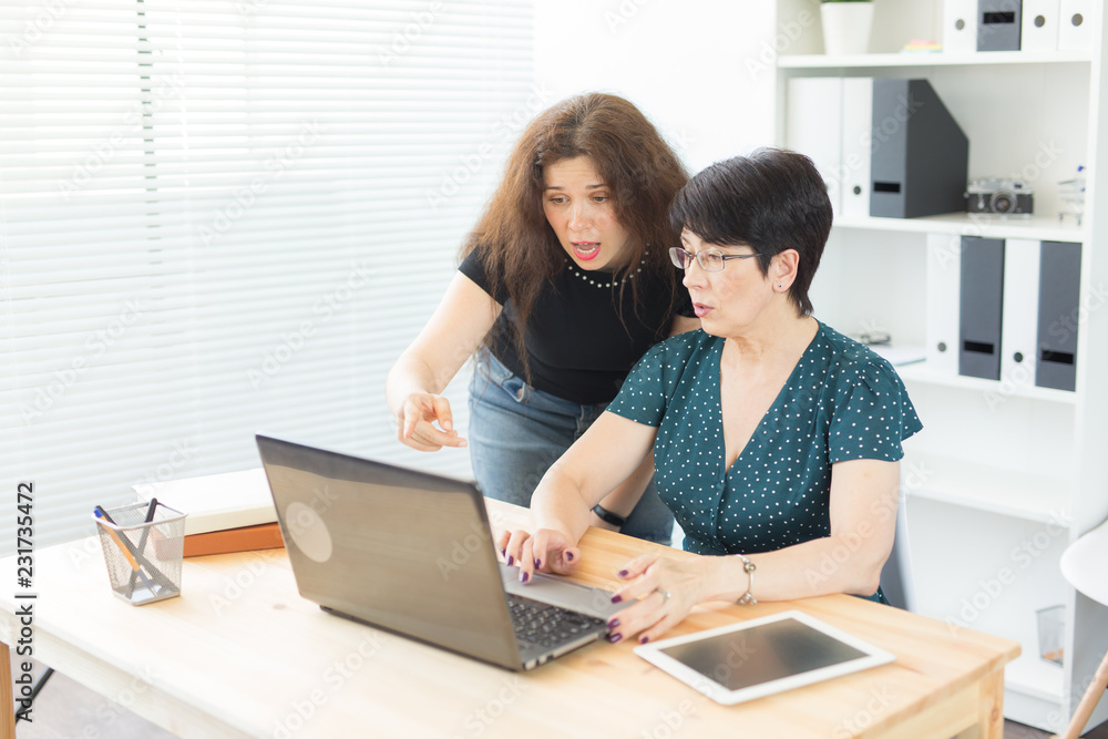 Business people and graphic designer concept - Women are discussing ideas at the office with laptop, pointing at the screen Business people and graphic designer concept - Women are discussing ideas at the office with laptop, pointing at the screen