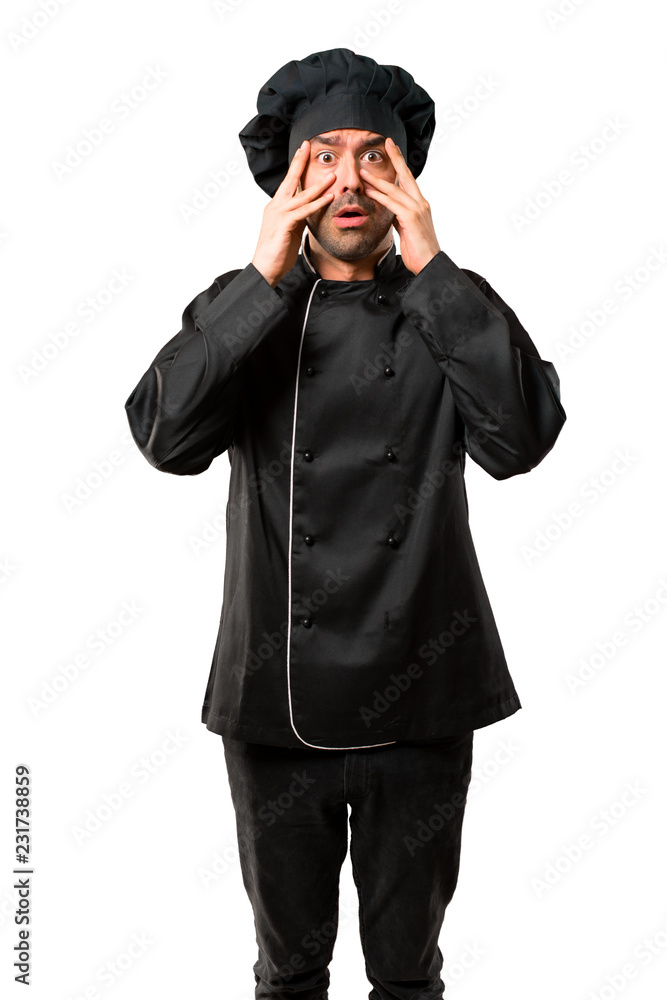 Chef man In black uniform surprised and covering face with hands while looking through fingers on isolated white background Chef man In black uniform surprised and covering face with hands while looking through fingers on isolated white background